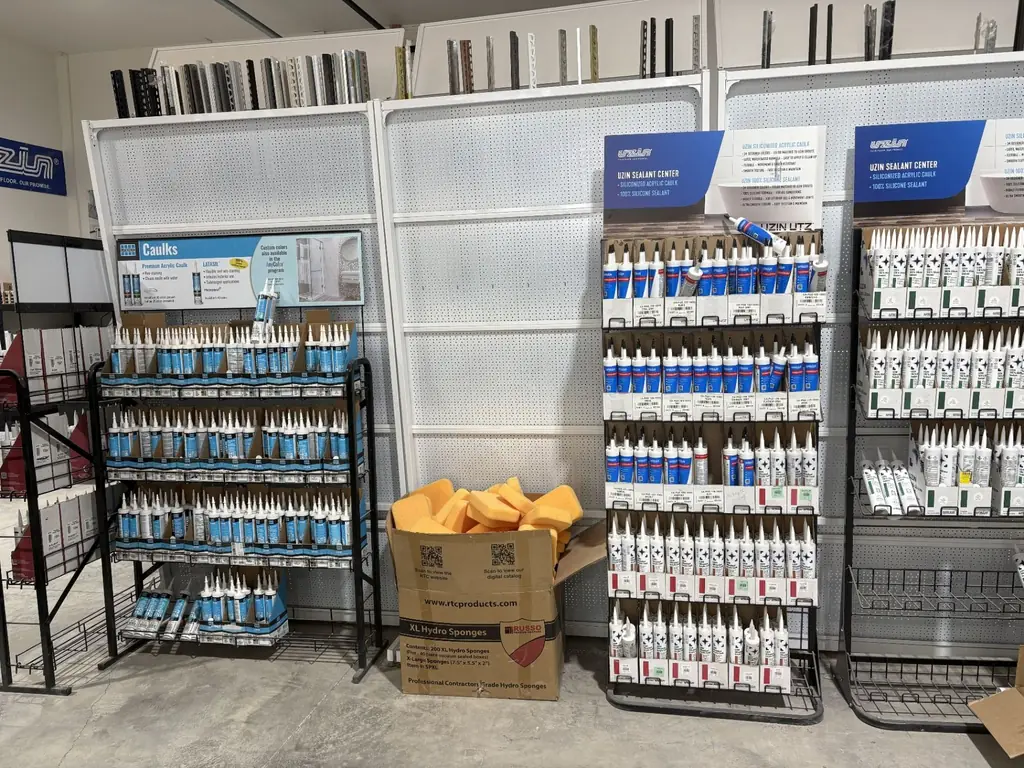 Uzin sealant and caulk center at Sundry Pro Shop with rows of siliconized acrylic caulk and 100% silicone tubes