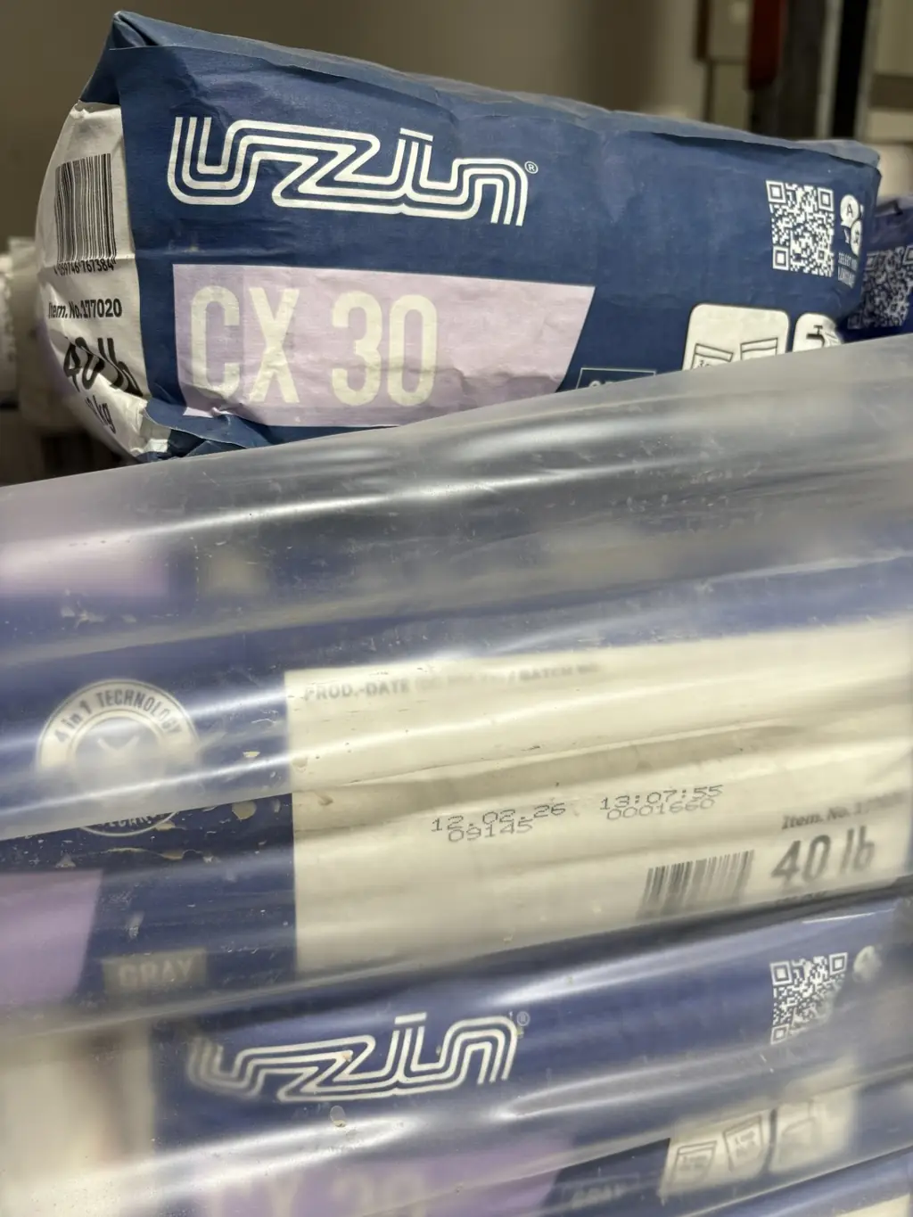 Bags of Uzin CX 30 gray large-format tile mortar on a pallet at Sundry Pro Shop